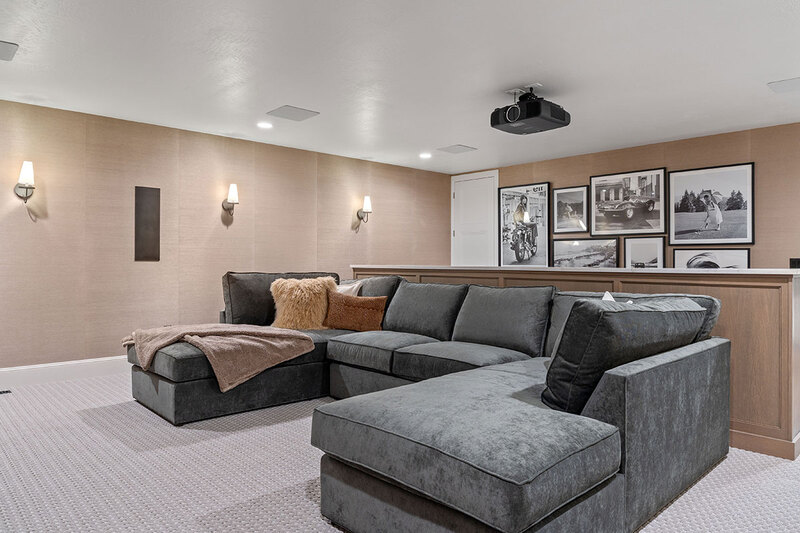 Down to Earth Projects<br>Symphony Homes Parade Ninth + North Design - Down to Earth Projects<br>Symphony Homes Parade Ninth + North Design - in-home movie room with gray sectional